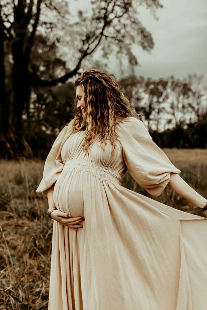 pregnant mother embracing her baby bump