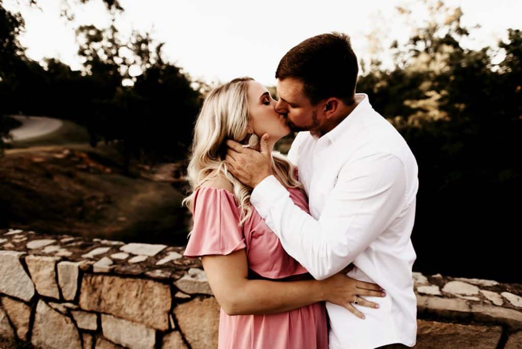 Couple kissing on brick bridge at Indian Springs Park