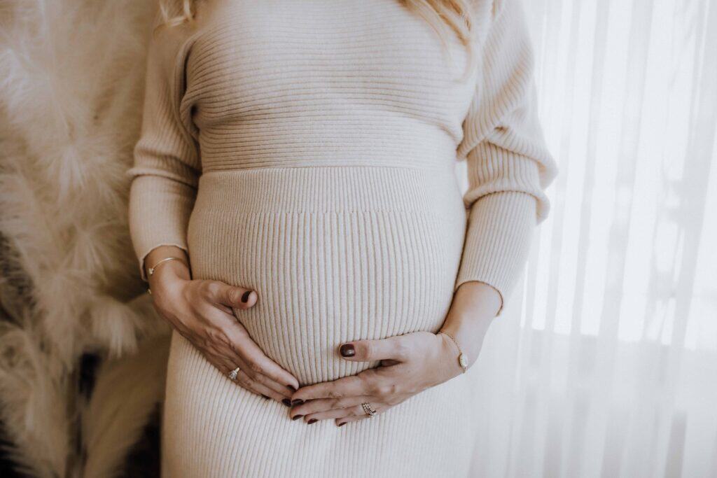 A Dreamy Studio Maternity Session in Downtown Macon 7 Close-up detail of hands on baby bump during studio maternity session