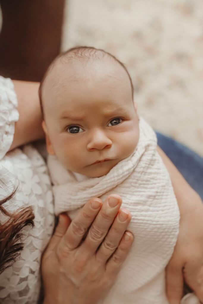 When to Schedule a Lifestyle Newborn Session (And What Age Works Best) 21 Close-up of a newborn wrapped in a neutral blanket, photographed in a natural, baby-led lifestyle session