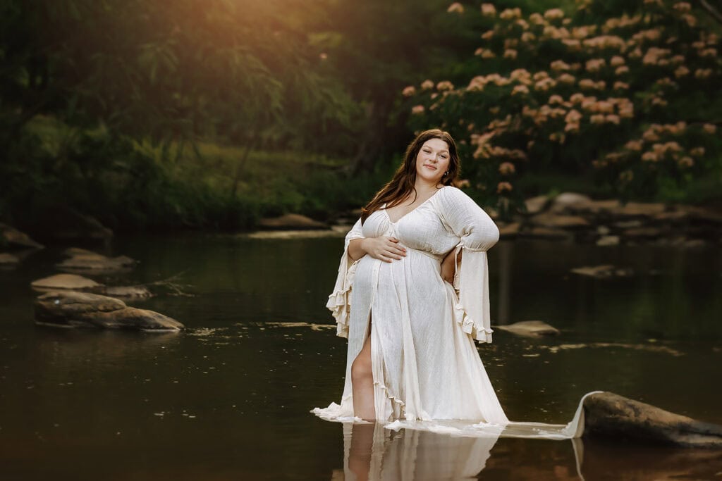 Maternity Photos When You Don’t Feel Your Best: What to Expect 2 Pregnant woman in a white dress standing in a creek during maternity photos