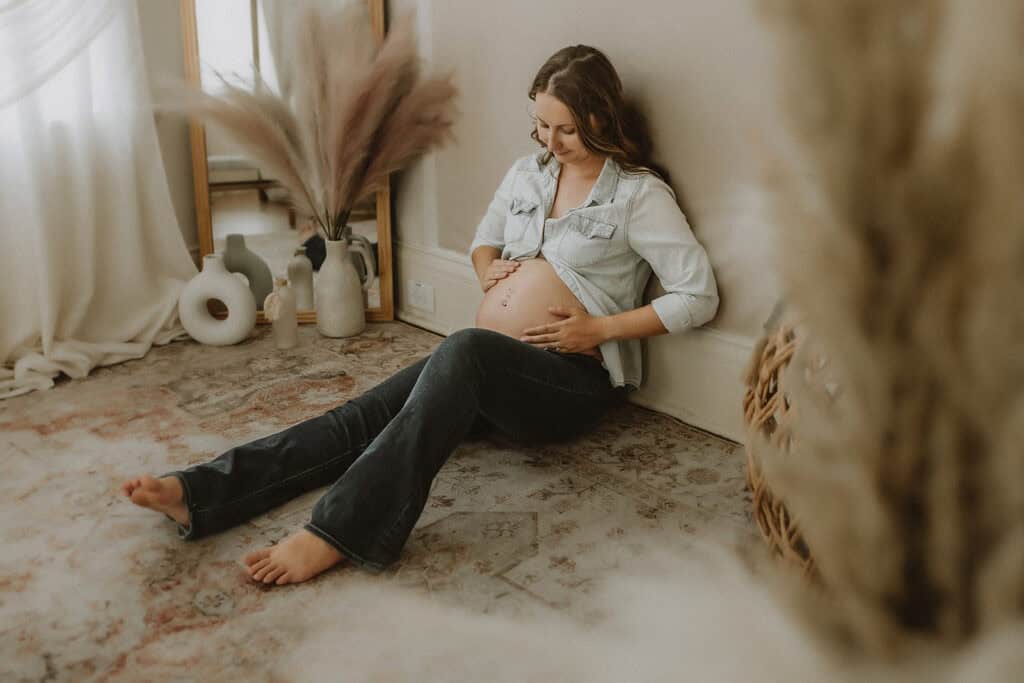 Best Time to Schedule Maternity Photos (So You Actually Feel Like Yourself) 10 Pregnant woman seated on the studio floor during a relaxed Macon maternity photography session