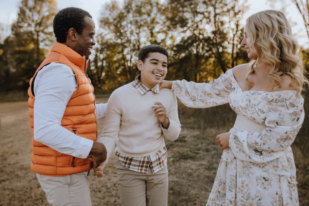 Why I Don't Promise Calm Family Photo Sessions (And Why That's a Good Thing) 5 Teenage boy laughing with his family during a candid family photography session.