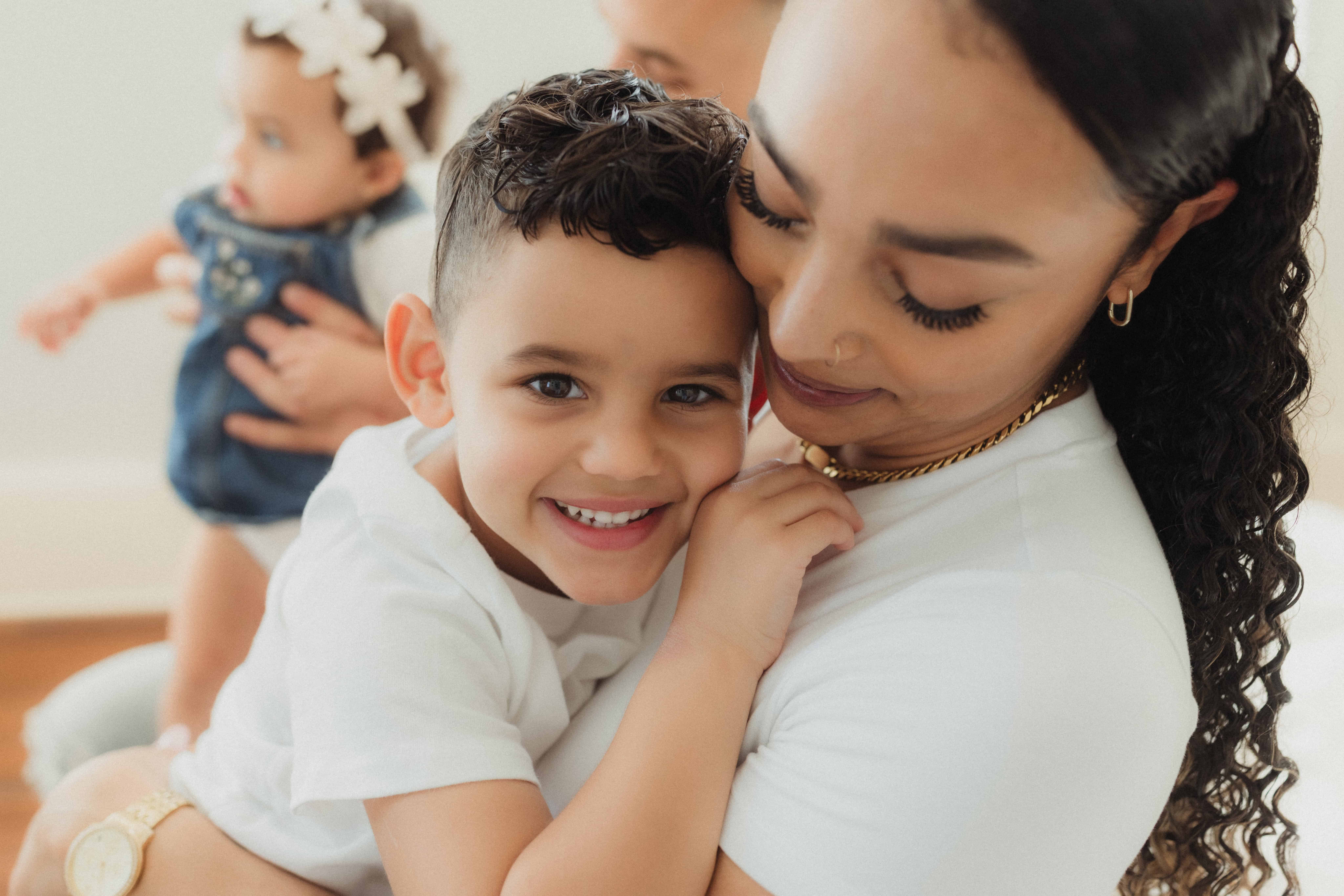How I Photograph Mothers Who Don’t Love Being in Photos 4 Warner Robins family photography session showing a mom holding her smiling toddler while her baby stands nearby, highlighting everyday family connection.