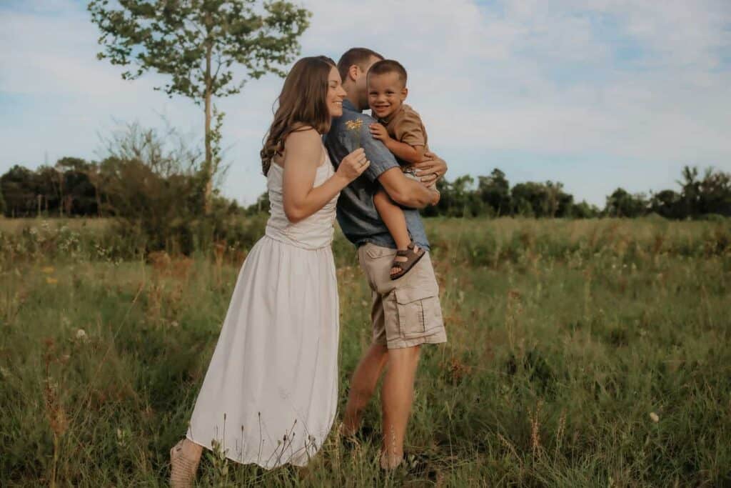 How Much Does a Family Photographer Cost in Macon GA? 7 Parents holding their young son during an outdoor family photography session near Macon, GA