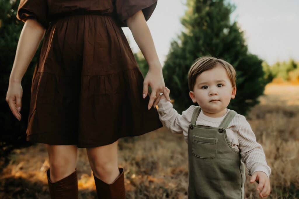 Middle Georgia Christmas Tree Farms: Your 2026 Family Guide 8 Mother holding her toddler’s hand among the Christmas trees at Roberts Christmas Tree Farm in Byron, Georgia