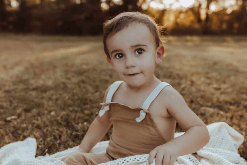 Young boy sitting outdoors during fall family photos in Middle Georgia