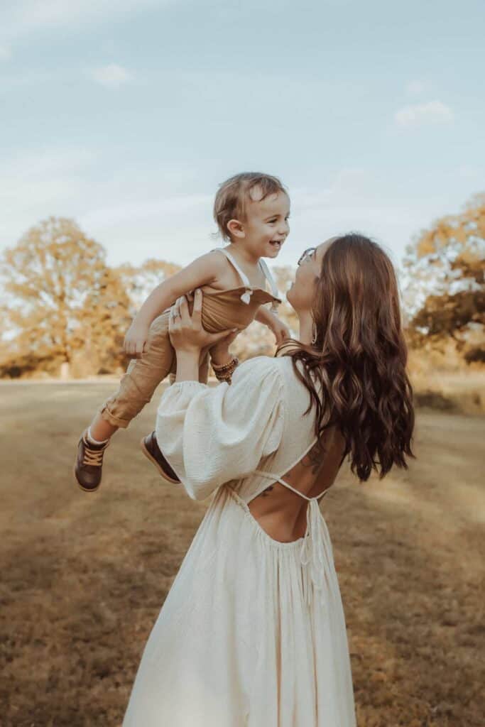 Mom lifting her young son during a fall family photography session