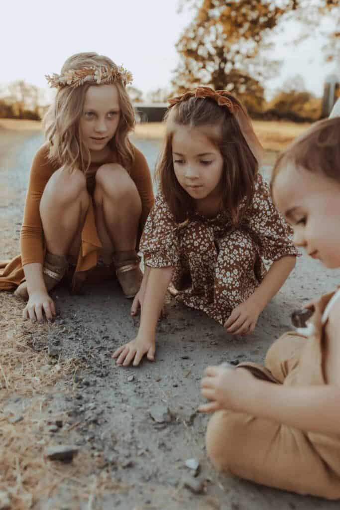 Three siblings playing together during an outdoor family photo session