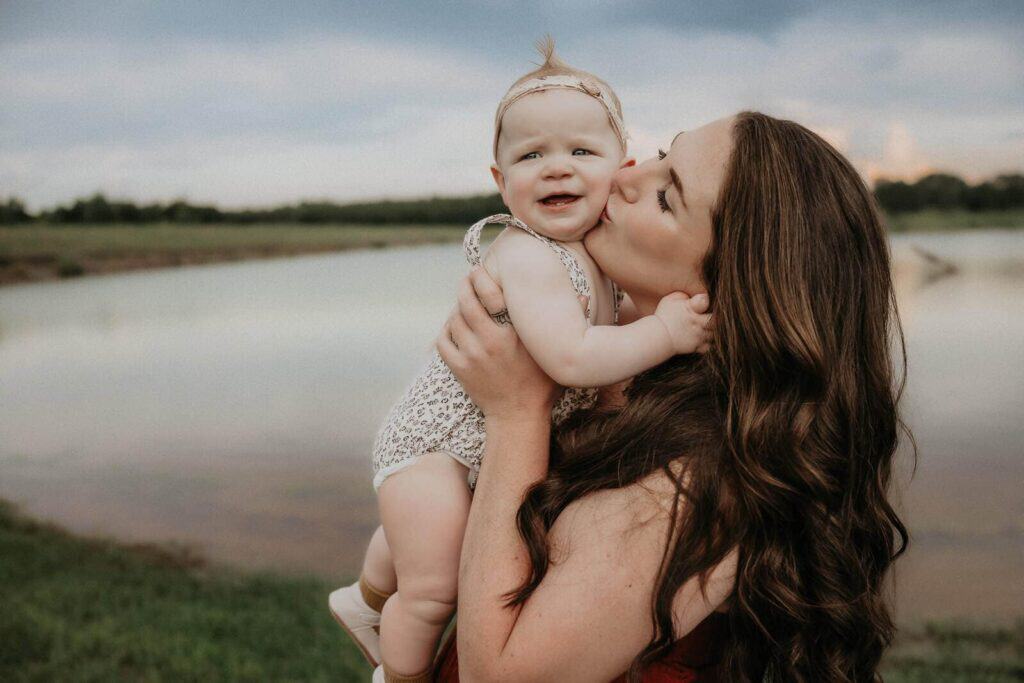 How to Choose a Family Photographer in Macon, GA 7 Mother kissing her baby during an outdoor motherhood and family photo session in Macon Georgia