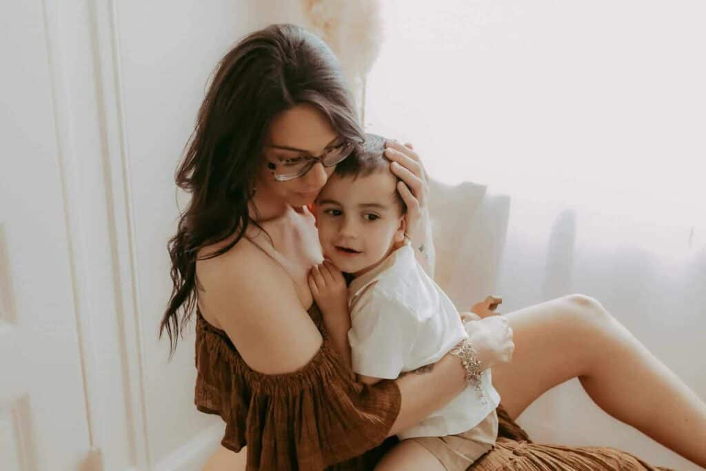 Warner Robins Pediatricians: A Local Guide for Families 3 Mother cuddling her young son near a window during an in-home family photography session