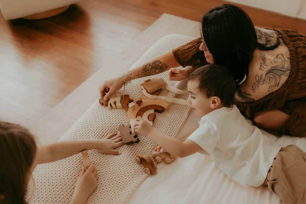 Warner Robins Pediatricians: A Local Guide for Families 6 Young boy playing with wooden toys on a bed during a relaxed family photography session